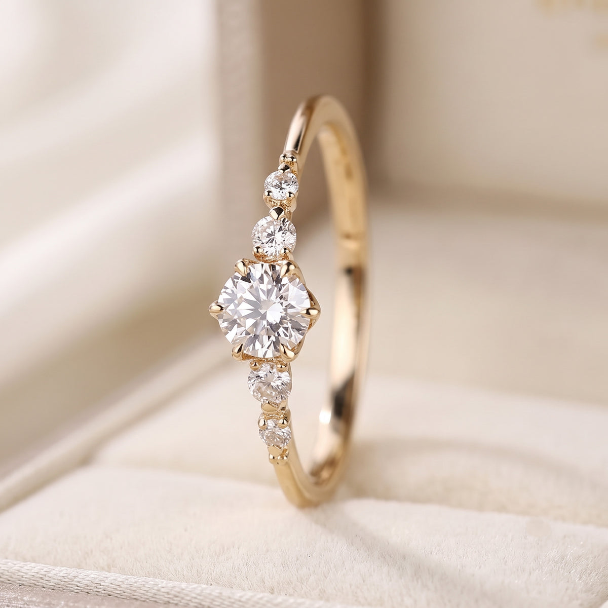 round cut diamond engagement ring with graduated side stones and petal gallery