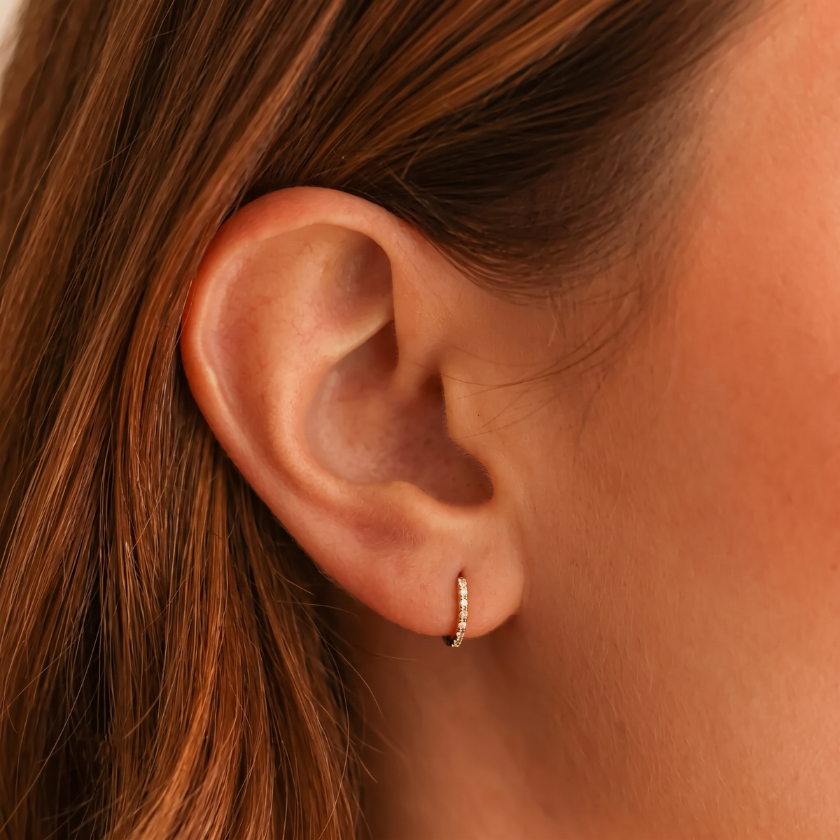 gold diamond huggie hoop earrings with pavé round stones