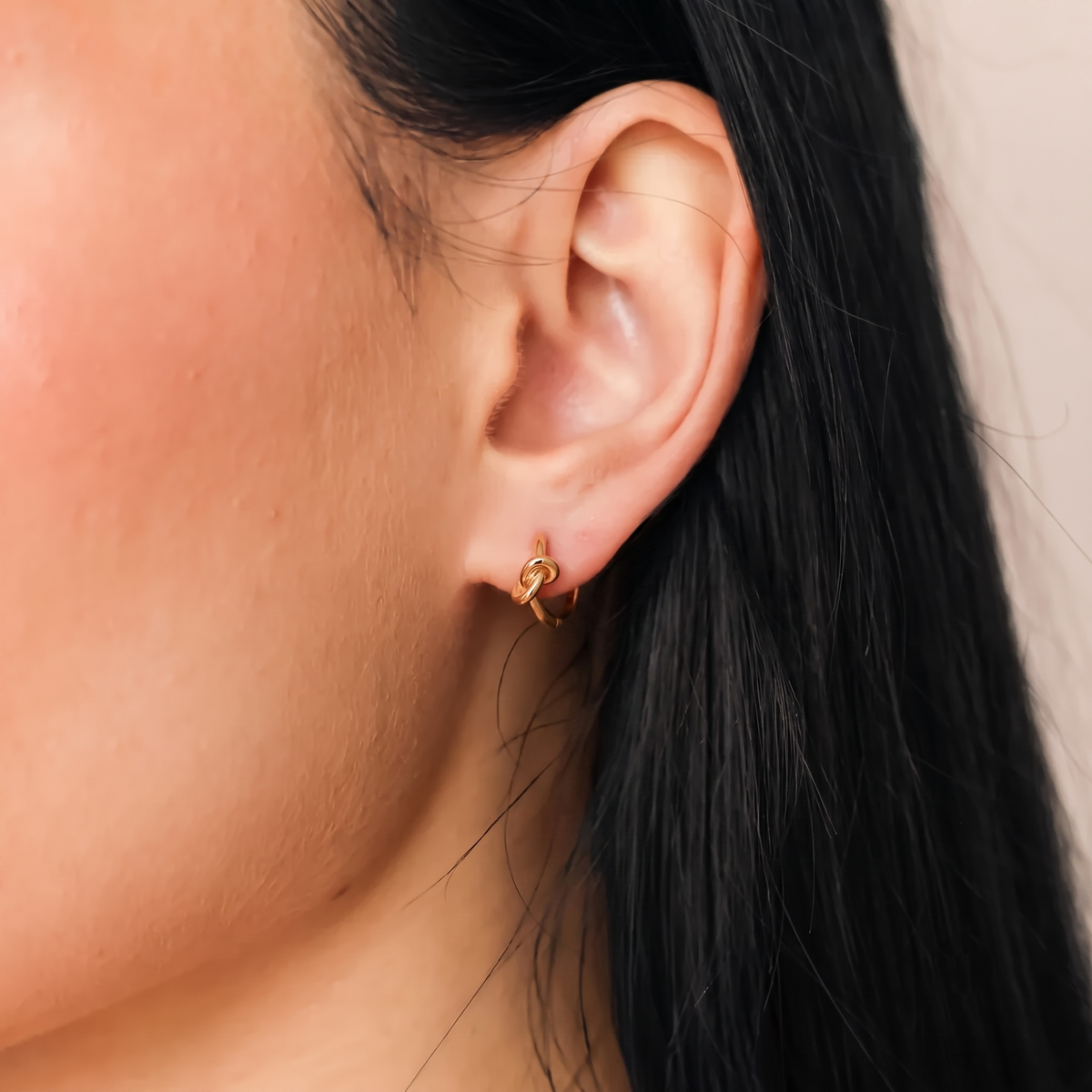 gold knot huggie hoop earrings with hinged snap closure
