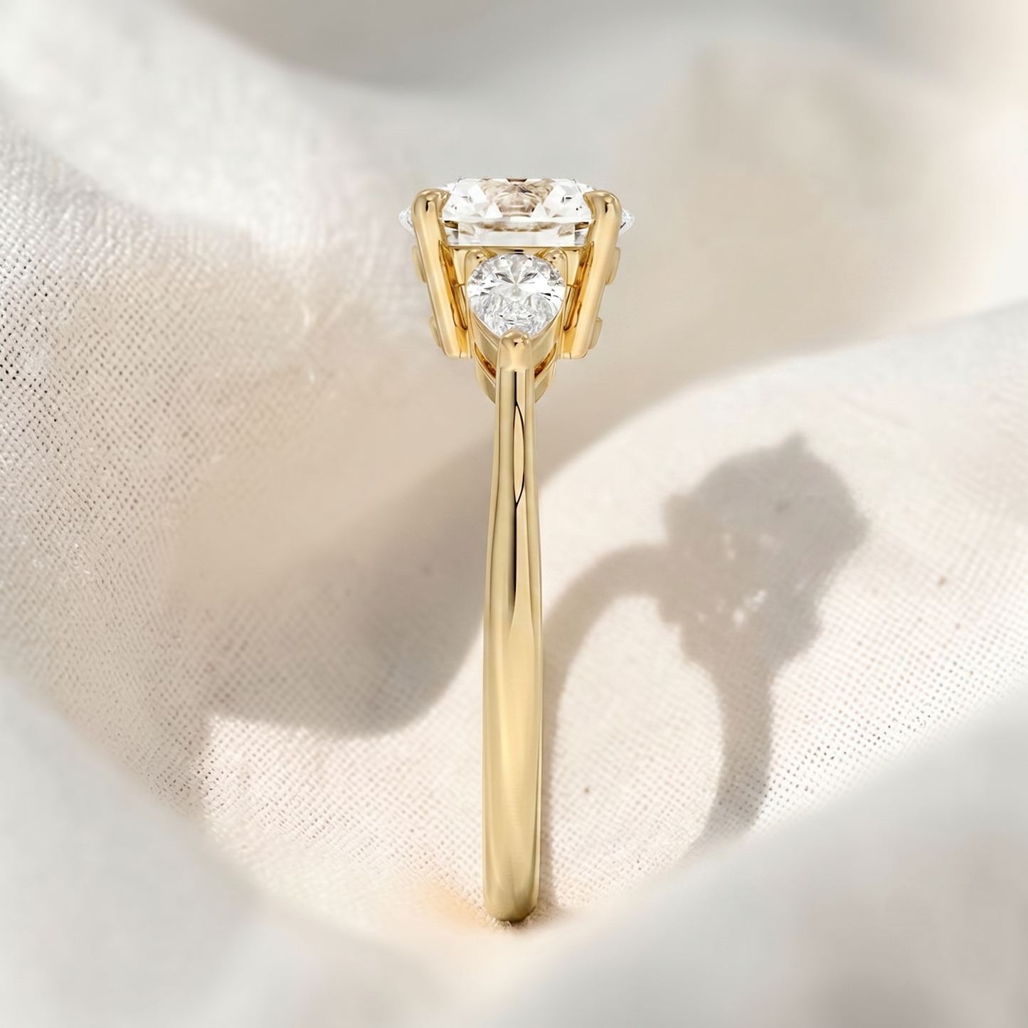 round lab grown diamond three stone engagement ring with pear side stones
