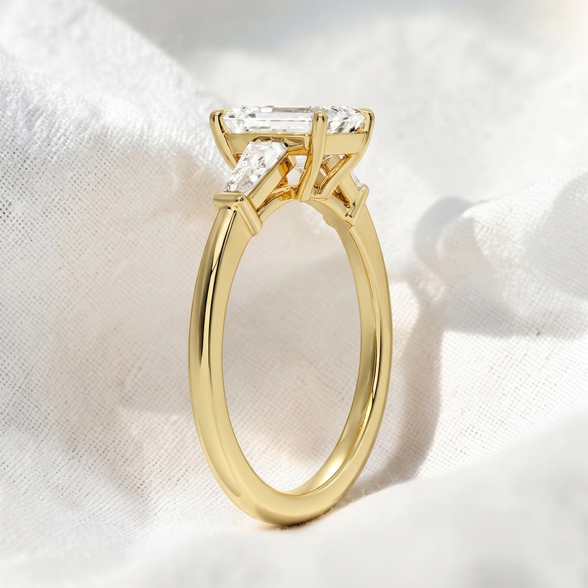 emerald cut lab grown diamond three stone engagement ring with tapered baguette side stones