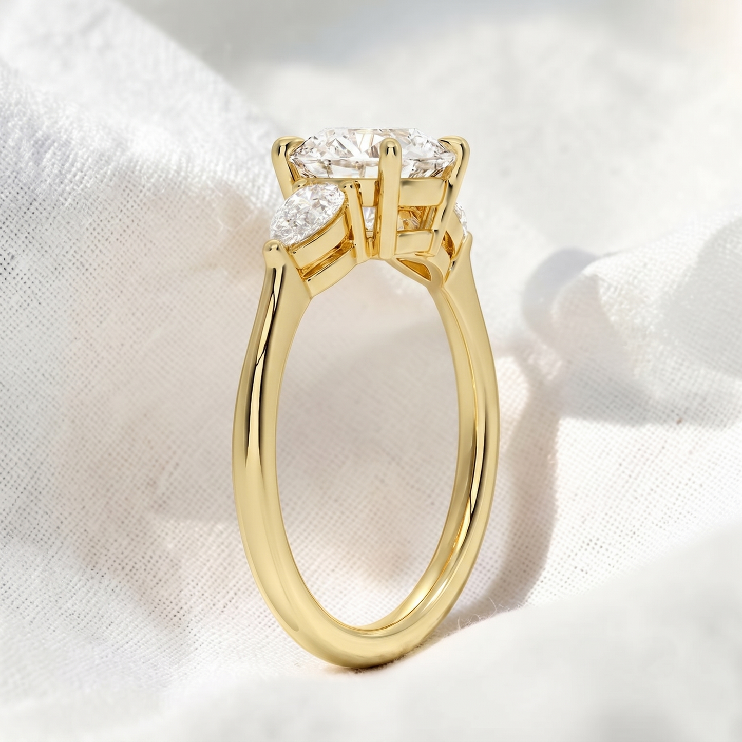 round lab grown diamond three stone engagement ring with pear side stones